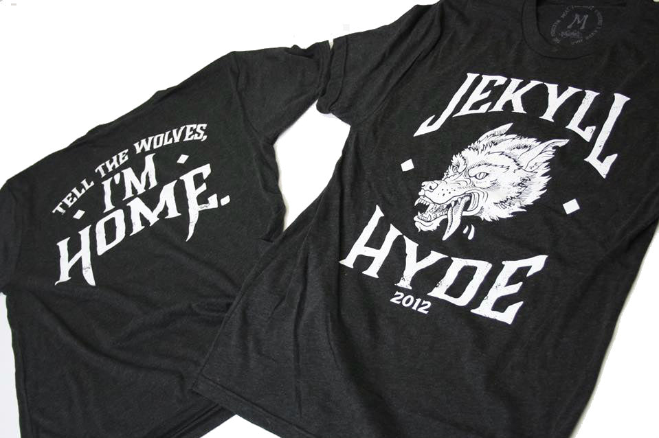 Black t-shirt on the ground with white print of a wolf and a slogan. 