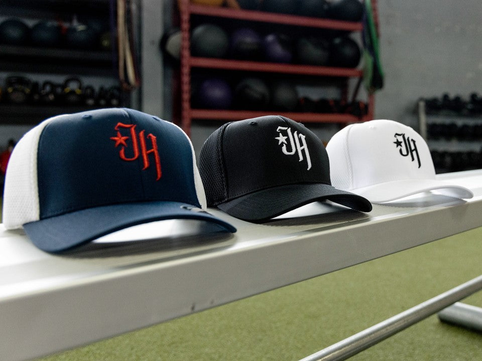 3 baseball hats on a bench