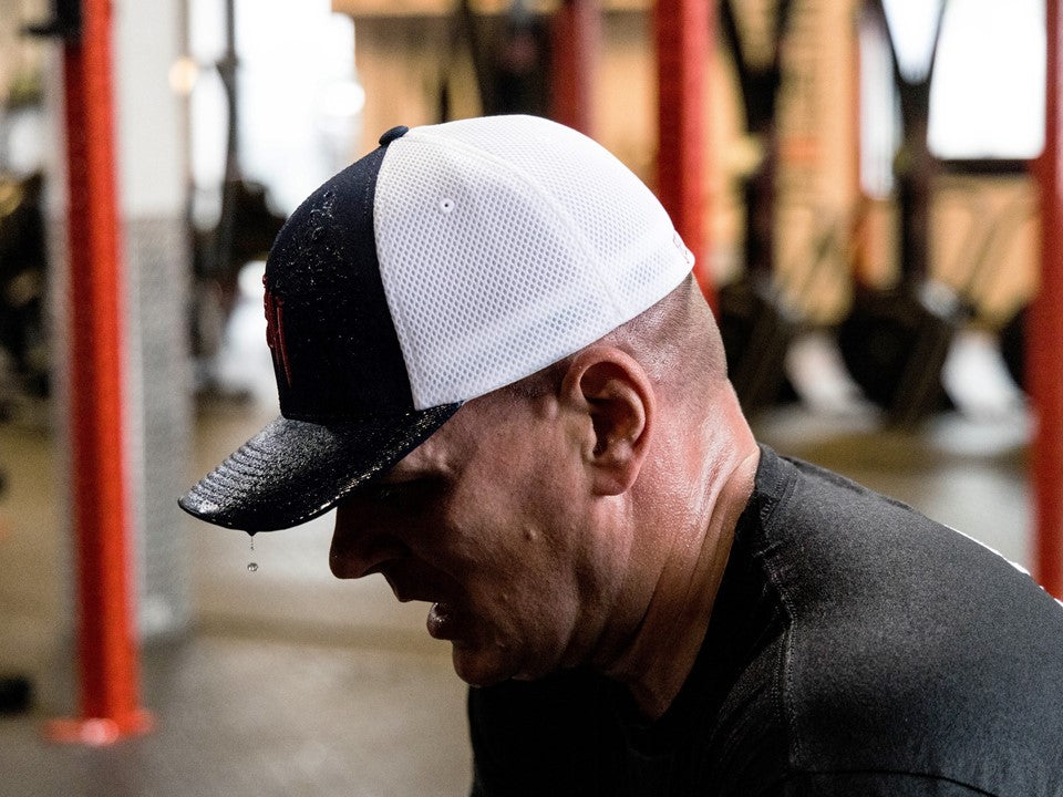 Man dripping sweat from his hat. 