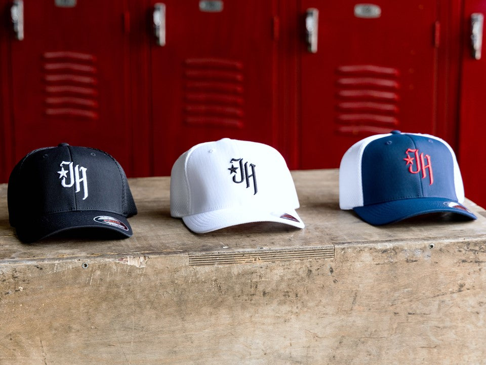 3 different color hats on a brown box. 