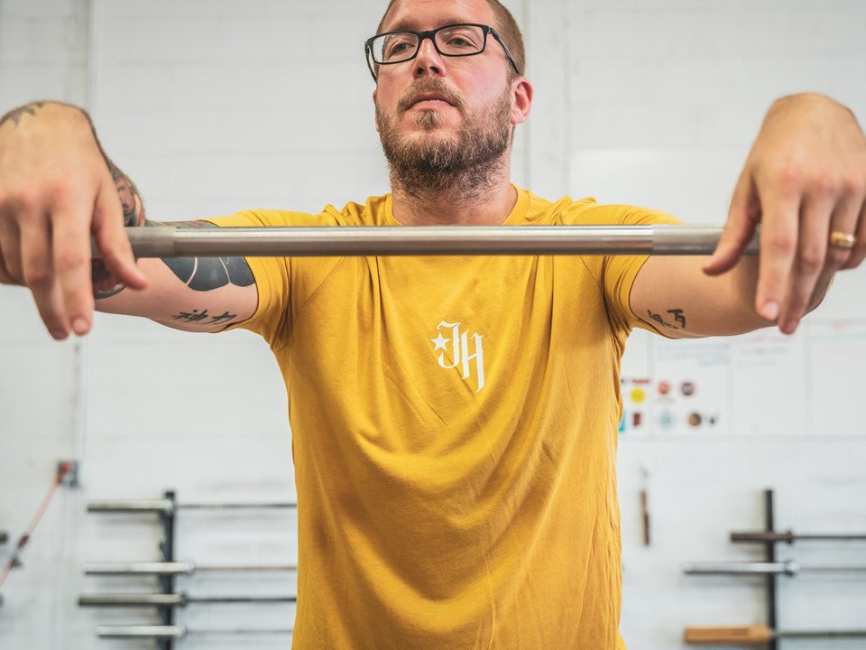Man standing with his arms on a barbell. 