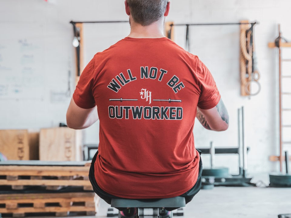 Man on rowing machine with his back to the camera. 