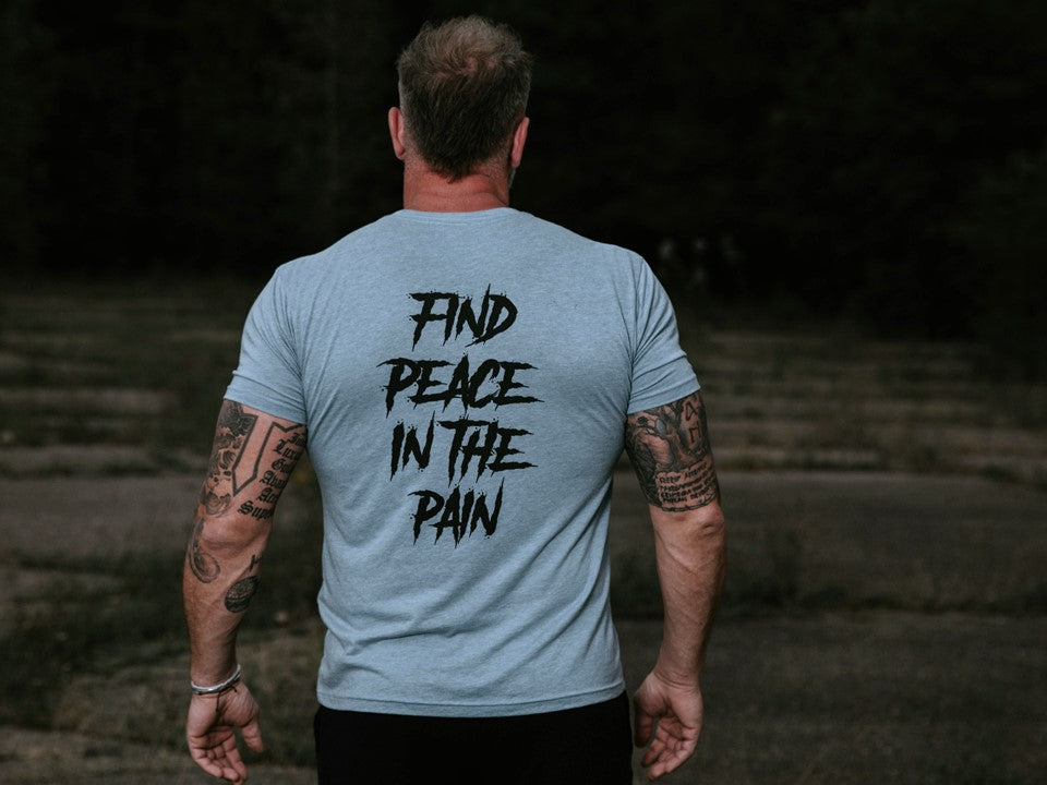 Man in a blue shirt with the words "Find Peace in the Pain" on the back. 