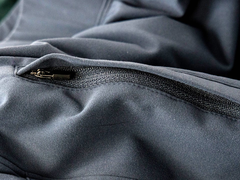 Close up of a zippered pocket of blue joggers. 