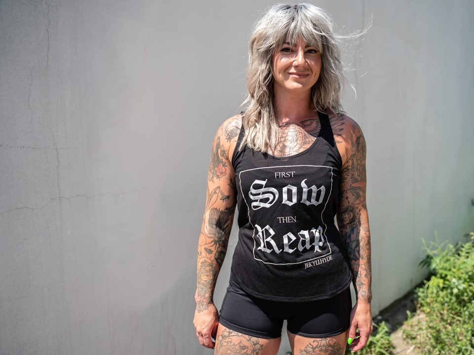Woman looking at the camera in a black tank top. 