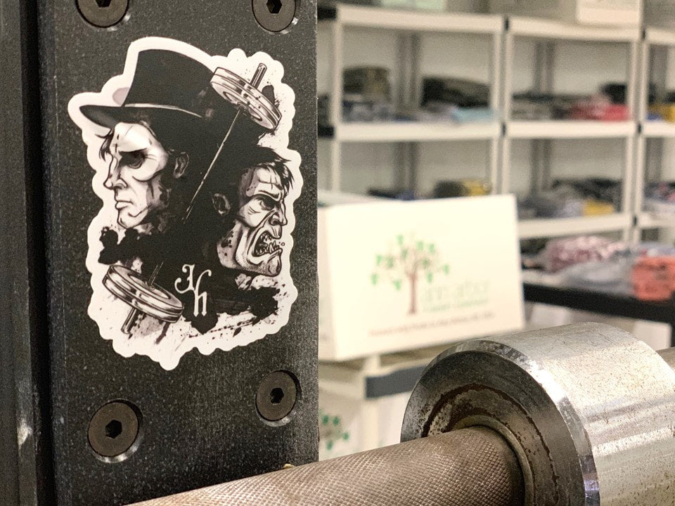 Sticker of a man and monster separated by a barbell on a squat rack. 