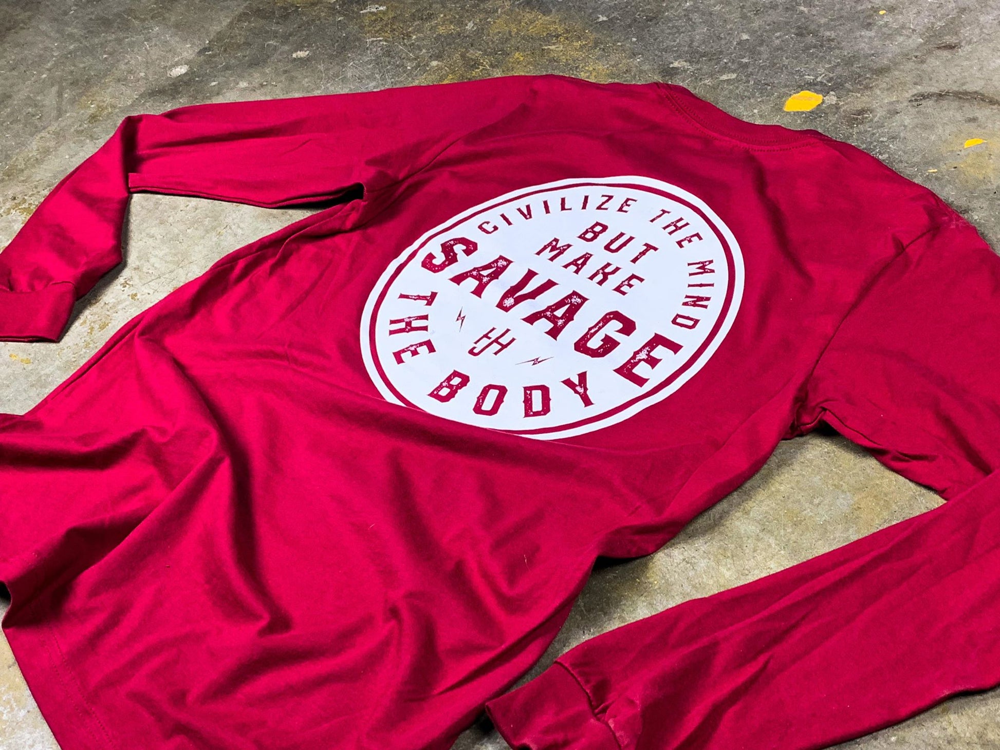 Flat lay of red shirt on concrete floor. 