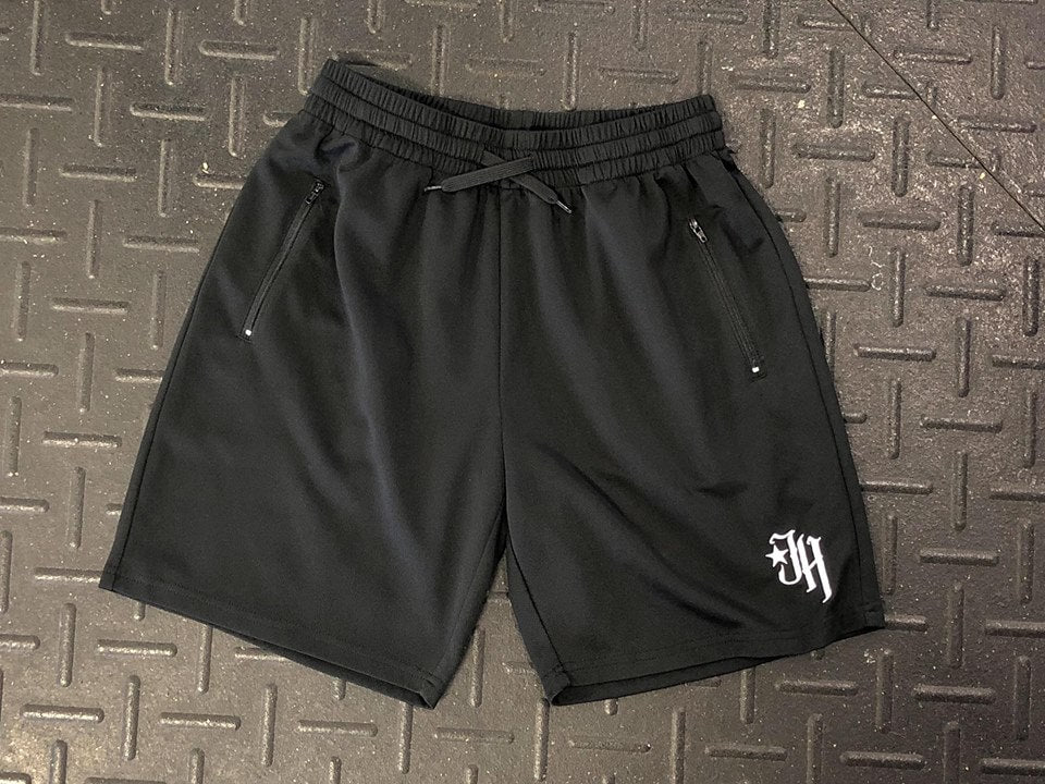 Flat lay of black shorts on a textured surface. 