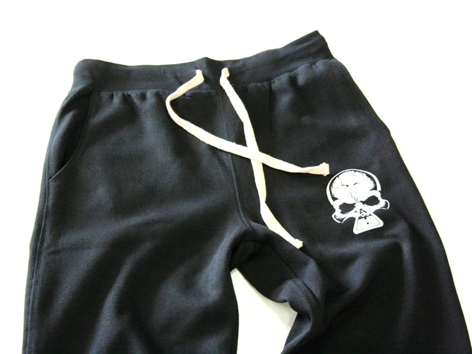 Black sweatpants with a skull logo on a white background. 