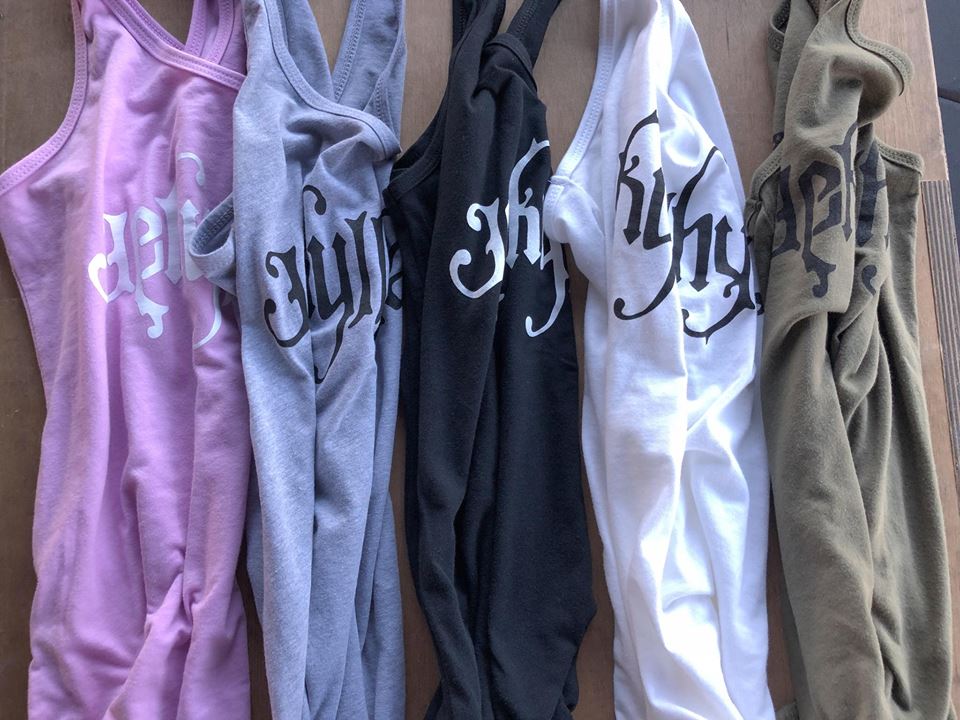 5 tank tops laying in a line