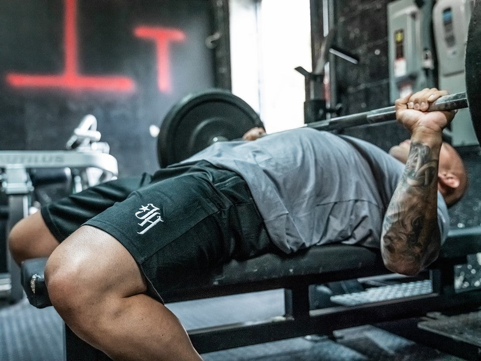 Black shorts on a man bench pressing. 