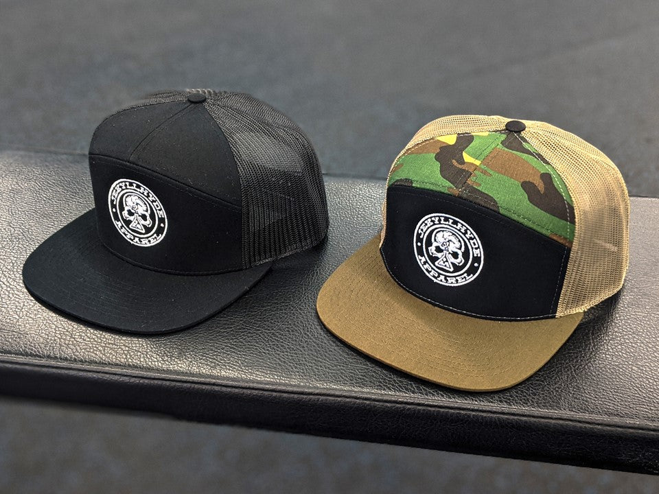 2 trucker hats sitting on bench. 