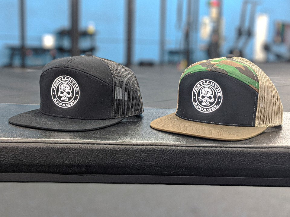 2 skull trucker hats on a bench. 