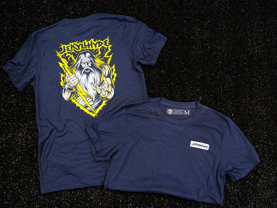 A blue shirt on the black turf, the shirt has Zeus on it. 